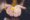Two hands, palms facing up, holding a thin yellow flower